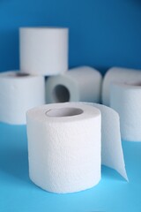 Soft toilet paper rolls on light blue background
