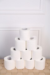 Pyramid of toilet paper rolls on wicker table