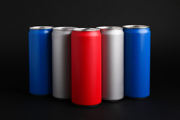 Energy drinks in colorful cans on black background