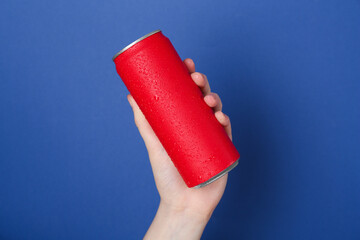 Woman with energy drink on blue background, closeup