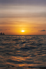 Boat travelling along the water at sunset