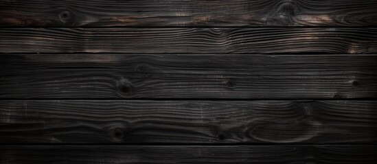 A close-up view of a dark wood background with a grainy surface, showcasing the intricate texture and patterns of the wood. The surface appears to be weathered and aged, adding depth to the overall