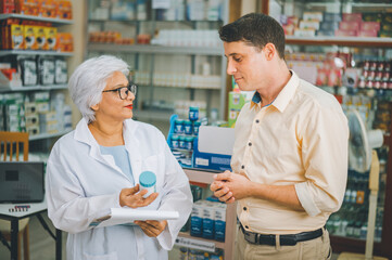 Obraz premium Pharmacist giving advice And advice for patients who come to buy Medicine, Drugs, Vitamins products, according to prescriptions in modern pharmacies.