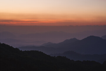 nature traveling with orange sky and layer of mountain with sunrise background
