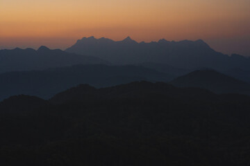 nature traveling with orange sky and layer of mountain with sunrise background