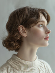 Portrait of a beautiful young Caucasian woman in a white sweater. profile shot, minimalistic editorial, elegant realism, chunky knit sweater exquisite details, sunlight. cream and white.