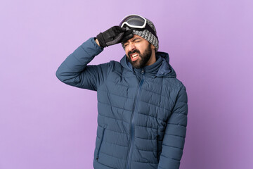 Skier man with snowboarding glasses over isolated purple background with tired and sick expression