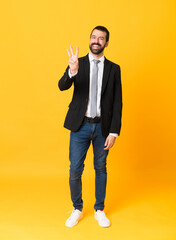 Full-length shot of business man over isolated yellow background happy and counting three with fingers