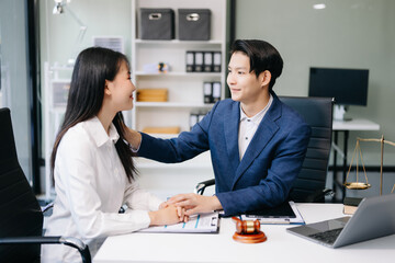 Judge gavel with scales of justice, Business and lawyer or counselor consulting and discussing contract papers with laptop and tablet at law firm .