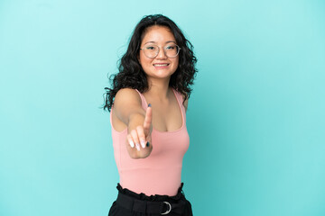 Young asian woman isolated on blue background showing and lifting a finger