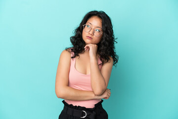 Fototapeta premium Young asian woman isolated on blue background with tired and bored expression