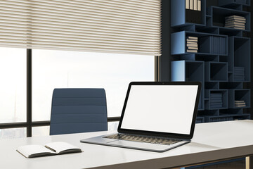 Creative designer desktop with empty white mock up laptop computer, supplies. Window with city view and blinds. 3D Rendering.