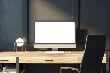 Stylish office setup with computer monitor, geometric lamp, and dark backdrop. Modern design concept. 3D Rendering