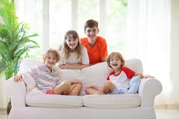 Obraz premium Kids play and watch tv on couch. Child at home.
