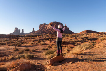 Woman with arms outstreched overlooking Monument Valley, Utah, USA