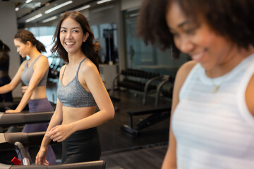 Young asian woman exercising on  treadmill at a gym.Active people running on treadmill. smile and funny emotion.