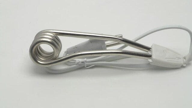 Slow motion panorama of travel immersion water heater on white background.