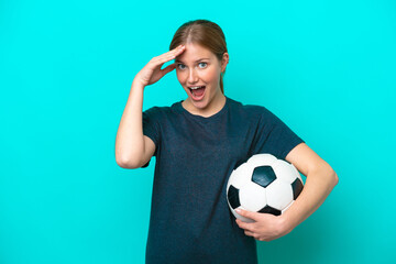 Young football player woman isolated on blue background with surprise expression