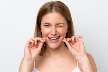Young caucasian woman isolated on white background using dental floss with happy expression. Close...