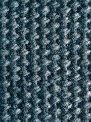 The image is of a blue and gray knit fabric with a fuzzy texture. The fabric appears to be made of wool and has a slightly worn look to it. Scene is cozy and comfortable.
