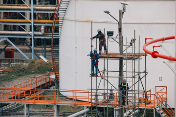 Construction workers installing scaffolding storage tank Oil​ refinery​ and​ plant and tower column of Petrochemistry industry