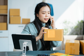 Portrait young attractive asian female owner startup business work happy with box at home prepare parcel delivery in sme supply chain, start up small business concept.