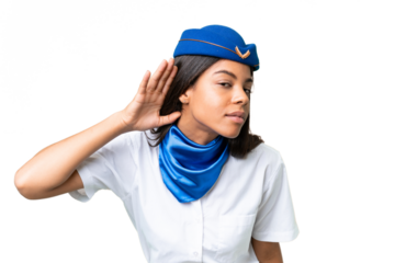 Airplane stewardess African american woman over isolated background listening to something by putting hand on the ear