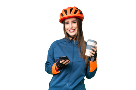 Young cyclist woman over isolated chroma key background holding coffee to take away and a mobile