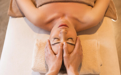 Relaxing anti-stress head massage. Cute woman relaxes in massage parlor during head massage, top view