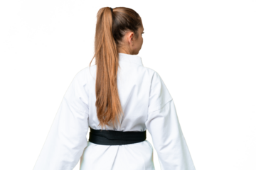 Young blonde woman over isolated chroma key background doing karate in back position