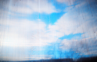 Fototapeta premium Daylight clouds through old plastic window limiter