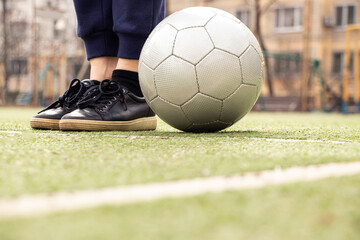 Female legs on a football field and a gray soccer ball in Ukraine,playing football in the yard