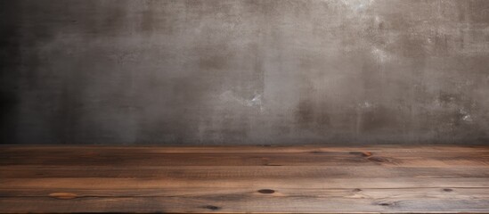 An empty wooden table is set against a grungy wall in the background, creating a raw and industrial aesthetic. The table appears weathered and worn, contrasting with the rough texture of the wall.