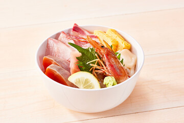 海鮮丼、白い木の板の上に丼物に入った新鮮な魚