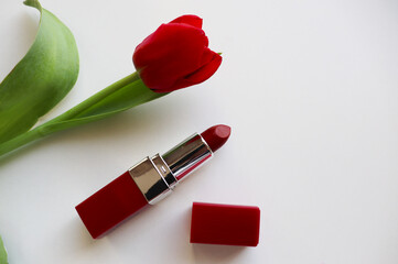 Obraz na płótnie Canvas red lipstick and bouquet of flowers on white background