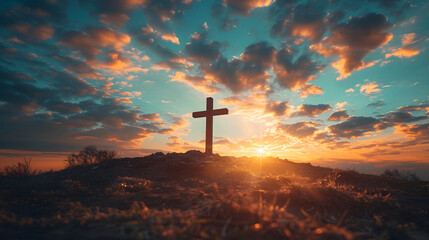 A wooden cross on a hill at sunset. The sky is a mix of blue, red, and purple clouds. - obrazy, fototapety, plakaty