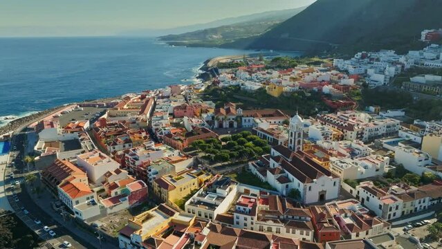 Aerial view of old town of Garachico on island of Tenerife, Canary. Flying over Garachico city center with colored houses. Ocean shore and lava pools. 