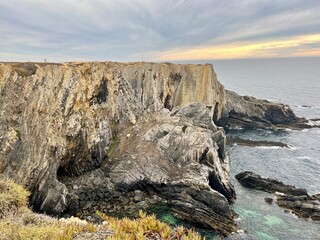 Fantastic rocky coast, cloudy sky, twilights time, ocean horizon