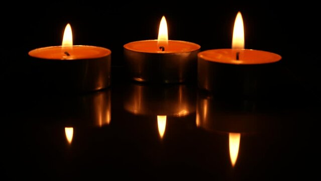 Three candles burning, isolated on black background. Concept of religion, death, memoriam and peace