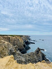 Fantastic rocky coast, cloudy sky, twilights time, ocean horizon