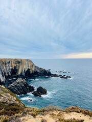 Fantastic rocky coast, cloudy sky, twilights time, ocean horizon