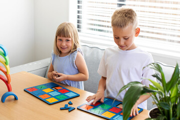 Brother and sister are playing educational wooden logic games. The concept of child development 