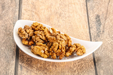 Cracked unshelled walnut in the bowl