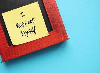 Note stick on photo frame on blue background with text message I RESPECT MYSELF, concept of...