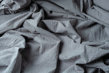 Gray abstract background of crumpled fabric with dark shadows
