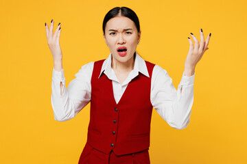 Young angry sad corporate lawyer employee business woman of Asian ethnicity in formal red vest shirt work at office spread hand scream shout isolated on plain yellow background studio Career concept