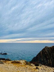 Fantastic rocky coast, cloudy sky, twilights time, ocean horizon