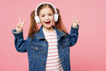 Little child smiling cute kid girl 7-8 years old wears denim shirt listen to music in headphones...