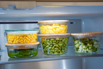 Bowls with vegetables and fruits in the refrigerator