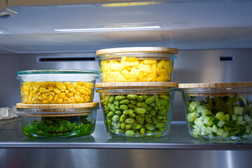 Bowls with vegetables and fruits in the refrigerator